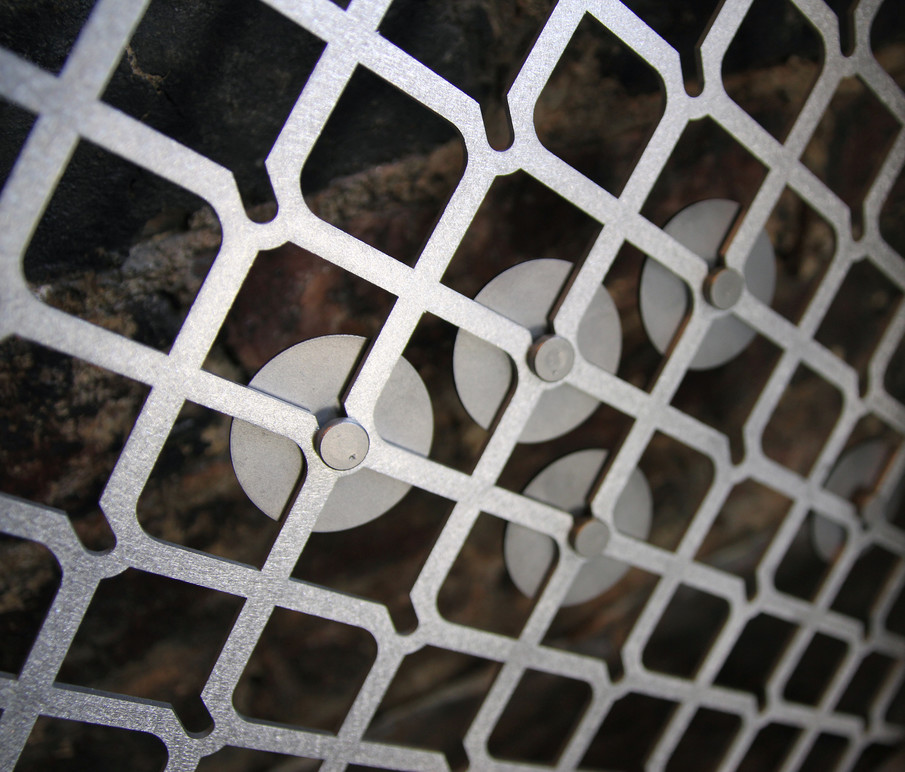 Metal pucks installed in metal framework.